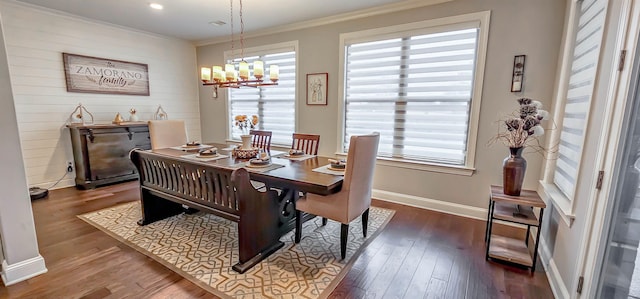 dining space featuring crown molding, a chandelier, and dark hardwood / wood-style flooring