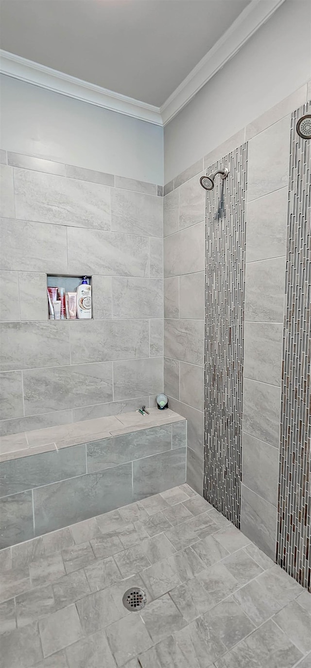 bathroom with tiled shower and crown molding