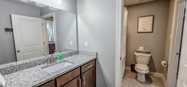 bathroom featuring vanity, tile patterned flooring, and toilet