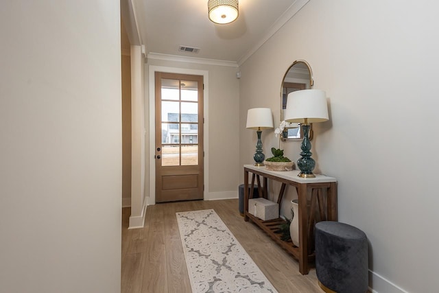 doorway featuring crown molding and light hardwood / wood-style flooring