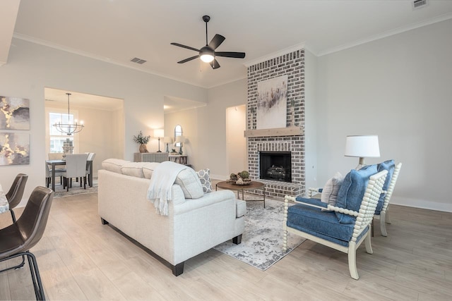 living room featuring a fireplace, ornamental molding, and light hardwood / wood-style floors