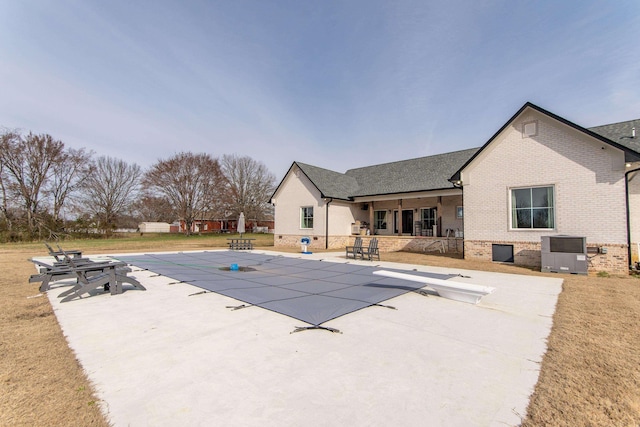 view of pool featuring a patio area, a diving board, and central AC unit