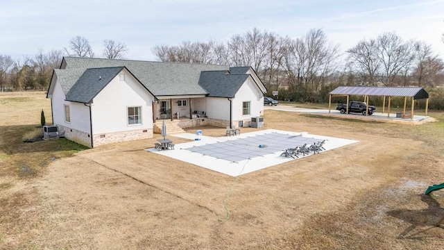 rear view of property featuring a patio, a carport, central AC unit, and a lawn