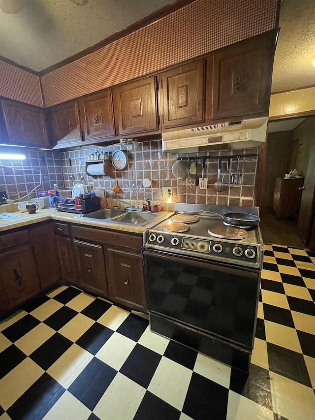 kitchen featuring sink, backsplash, black electric range, a textured ceiling, and dark brown cabinets