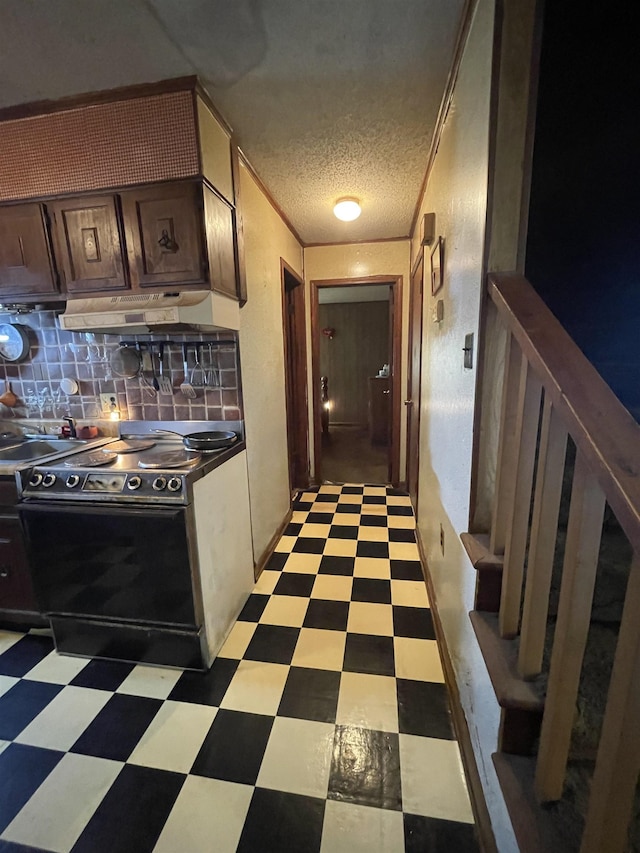 kitchen featuring tasteful backsplash, dark brown cabinetry, a textured ceiling, black / electric stove, and sink