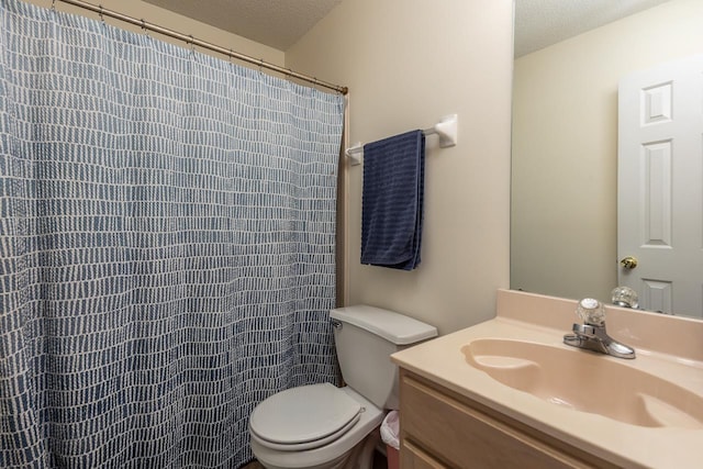 bathroom featuring a textured ceiling, toilet, vanity, and walk in shower