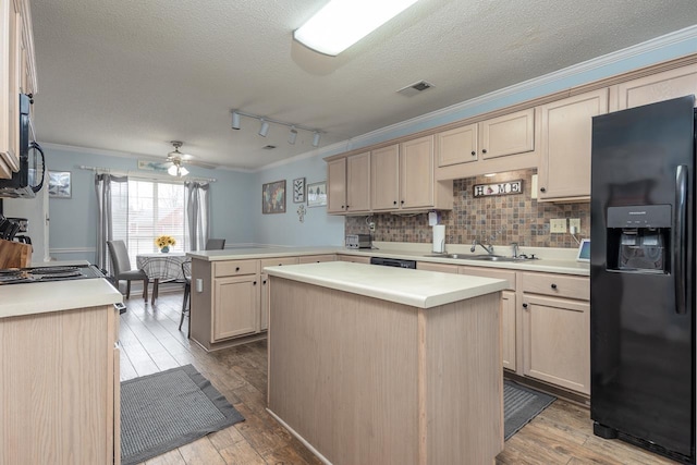 kitchen with a kitchen island, sink, kitchen peninsula, and black refrigerator with ice dispenser