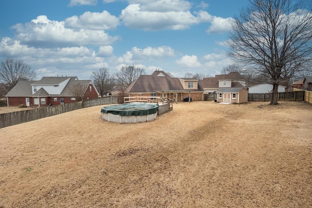 view of yard featuring a covered pool and a storage unit