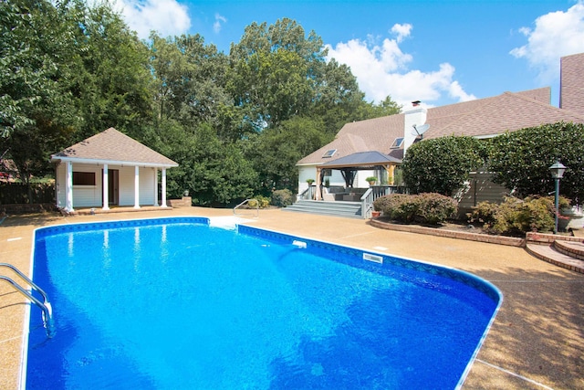 view of pool with a patio, an outdoor structure, and a gazebo