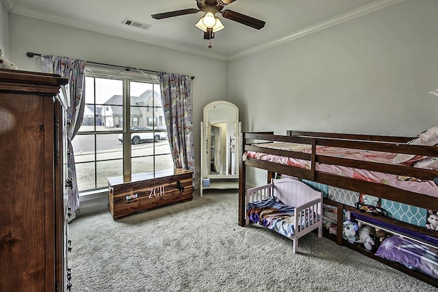 carpeted bedroom featuring ceiling fan and ornamental molding