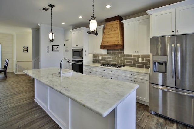 kitchen with white cabinetry, pendant lighting, stainless steel appliances, and a kitchen island with sink