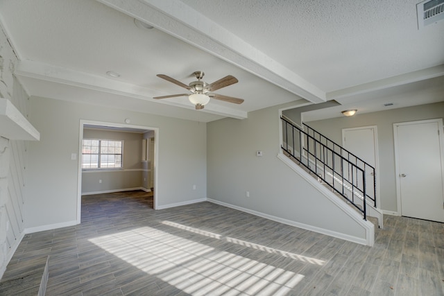 unfurnished living room featuring hardwood / wood-style floors, ceiling fan, a textured ceiling, and beam ceiling