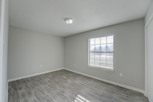 unfurnished room with light hardwood / wood-style floors and a textured ceiling