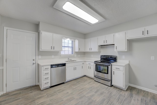 kitchen featuring light wood-type flooring, appliances with stainless steel finishes, white cabinetry, and sink