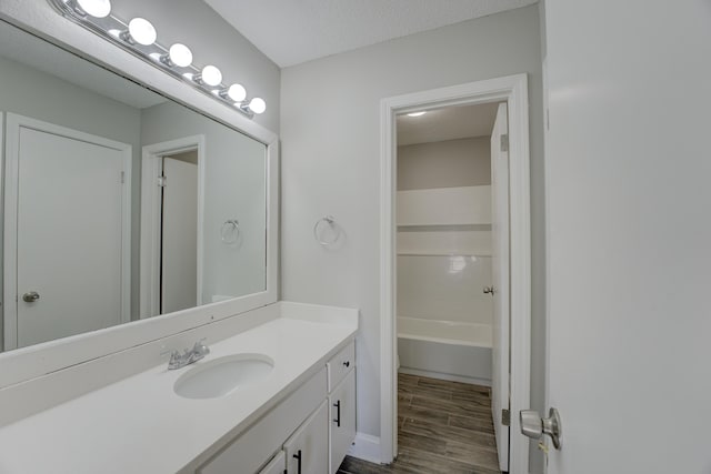 bathroom with vanity, a textured ceiling, and hardwood / wood-style floors