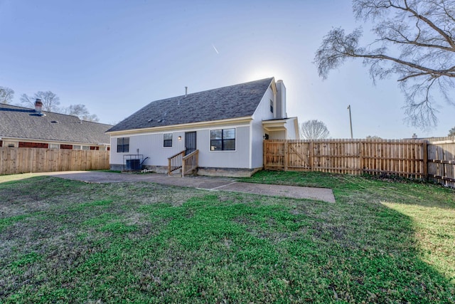 rear view of house with central AC unit, a yard, and a patio area