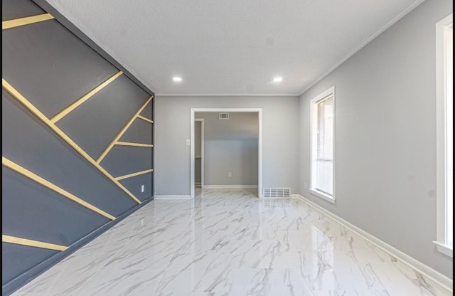 spare room with a textured ceiling and crown molding