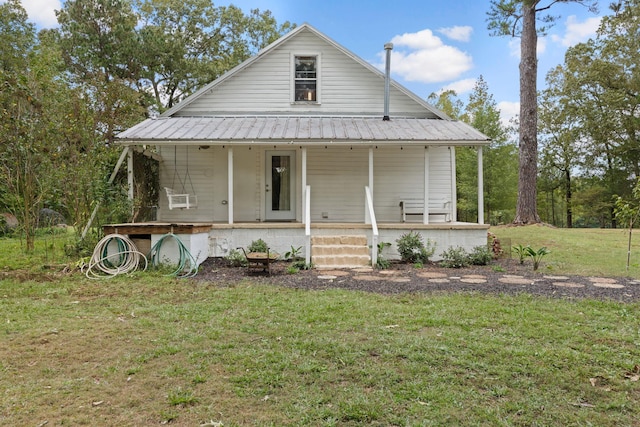 farmhouse featuring a front lawn and covered porch