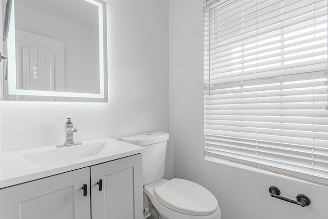 half bathroom featuring vanity and toilet