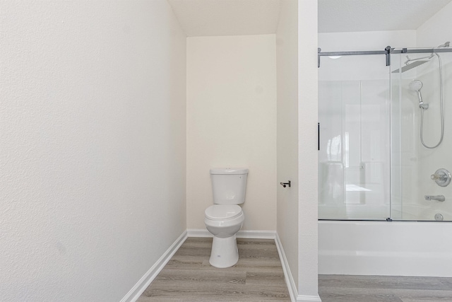 full bathroom featuring baseboards, toilet, and wood finished floors