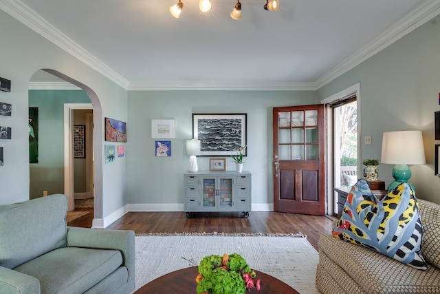 living room featuring arched walkways, dark wood-style flooring, baseboards, and ornamental molding