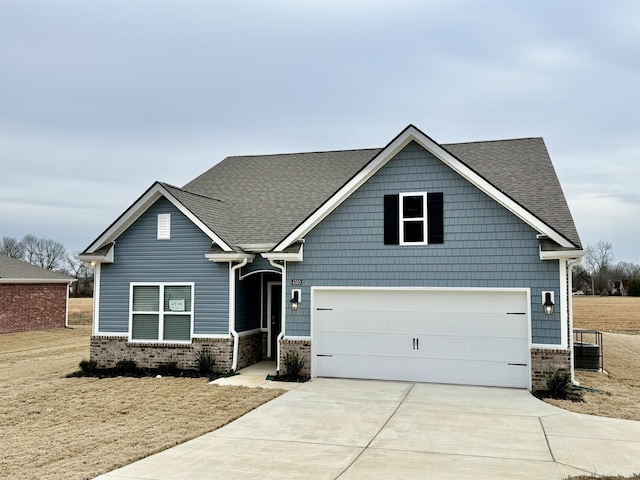 craftsman-style house with a garage, brick siding, concrete driveway, and roof with shingles