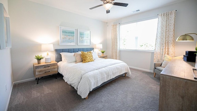 bedroom with visible vents, dark carpet, baseboards, and ceiling fan