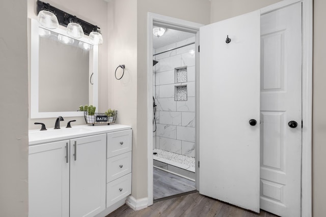 bathroom with a stall shower, vanity, and wood finished floors