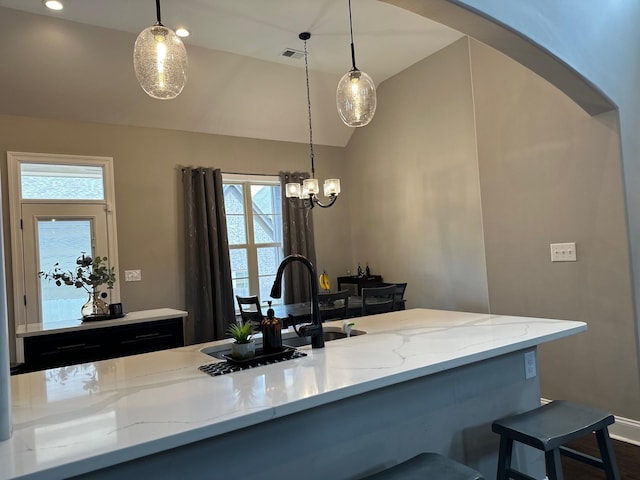 kitchen featuring visible vents, pendant lighting, and light stone counters