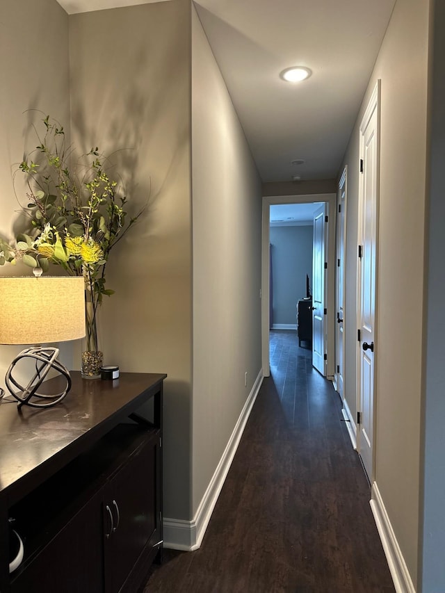 hallway with dark wood finished floors and baseboards