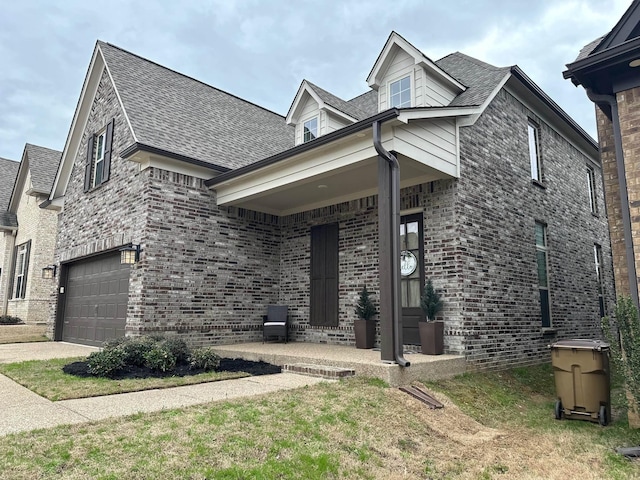 view of front of property with driveway, brick siding, and roof with shingles