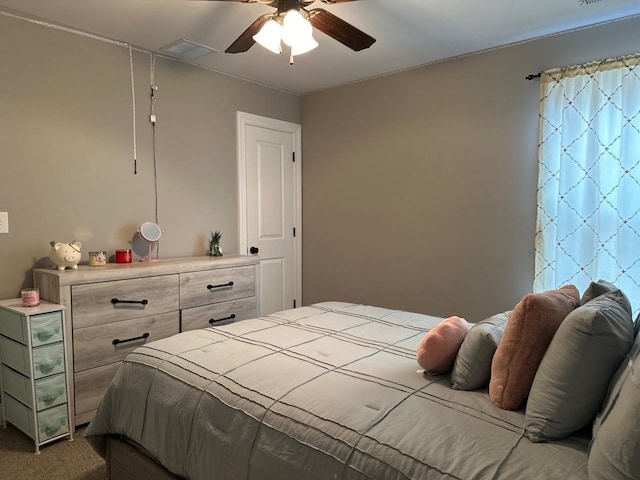 carpeted bedroom with visible vents and a ceiling fan