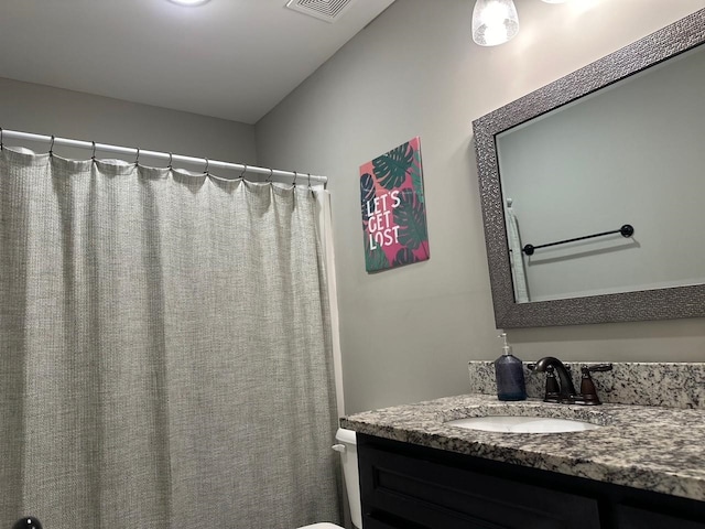 full bathroom with toilet, visible vents, and vanity