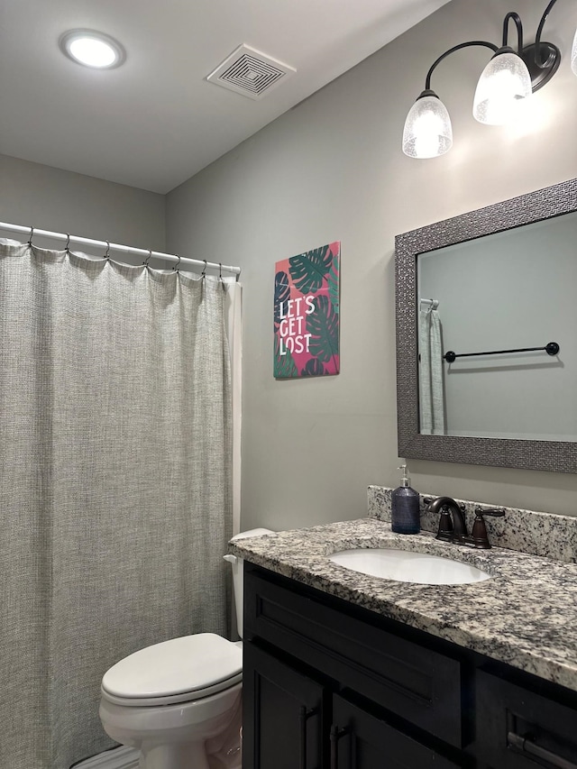 full bath with visible vents, vanity, and toilet