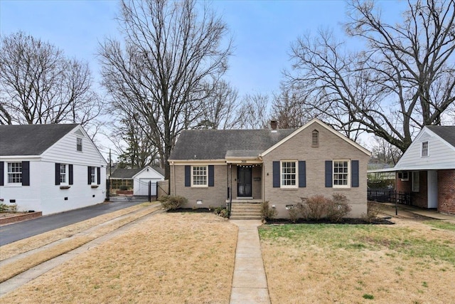 bungalow-style home featuring brick siding, crawl space, a chimney, and a front lawn