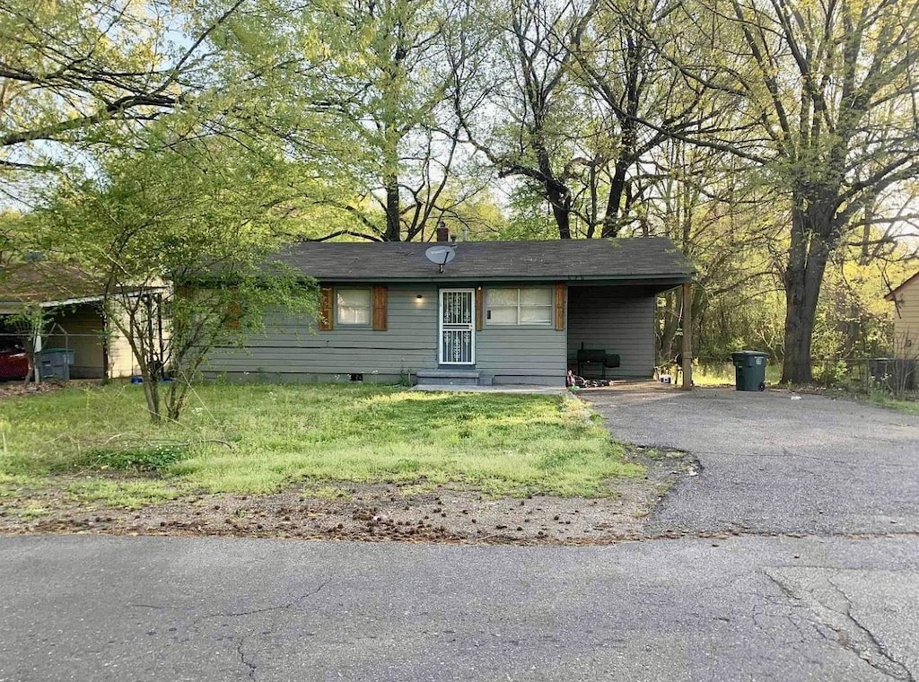 view of front of home with driveway and a front lawn