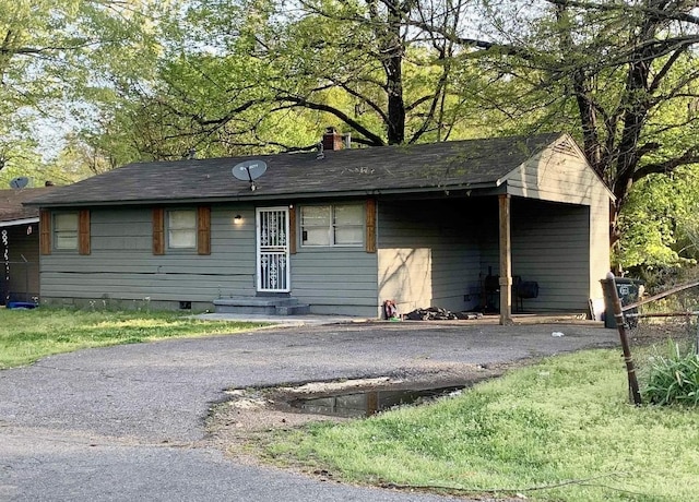 ranch-style home with entry steps, aphalt driveway, and a chimney