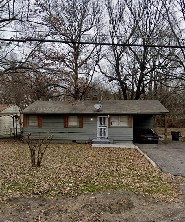 ranch-style house with driveway, an attached carport, and crawl space