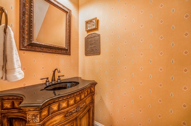 bathroom featuring vanity and wallpapered walls