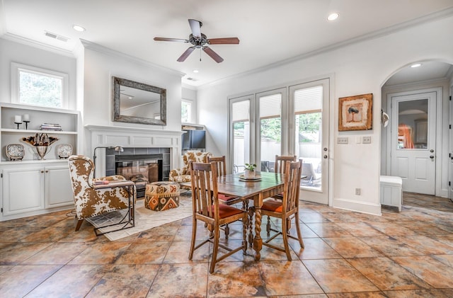 dining space with baseboards, a fireplace, visible vents, and ornamental molding