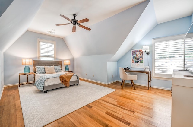 bedroom with lofted ceiling, visible vents, baseboards, and wood finished floors