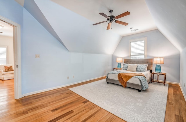 bedroom with lofted ceiling, light wood finished floors, visible vents, and baseboards