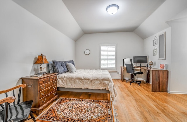 bedroom with lofted ceiling, baseboards, and light wood finished floors