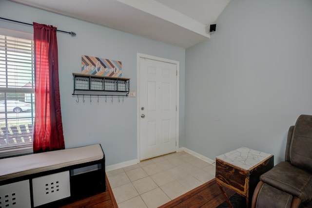 foyer entrance featuring light tile patterned flooring and baseboards