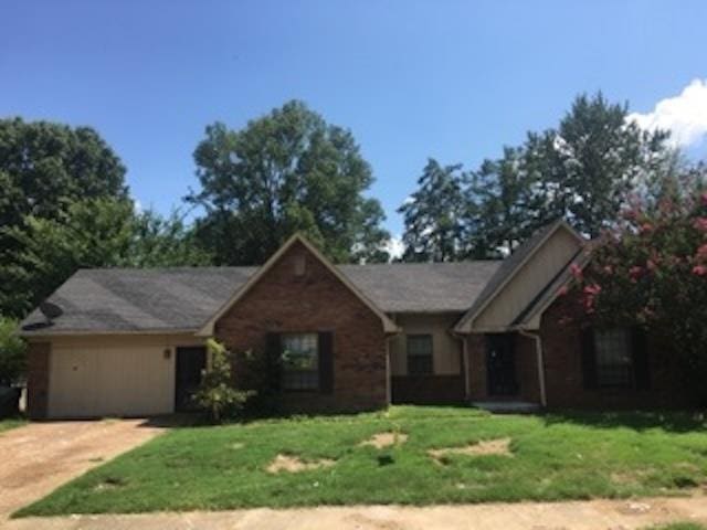 ranch-style house with driveway, a front lawn, and an attached garage