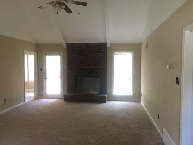 unfurnished living room with carpet floors, a fireplace, and lofted ceiling with beams