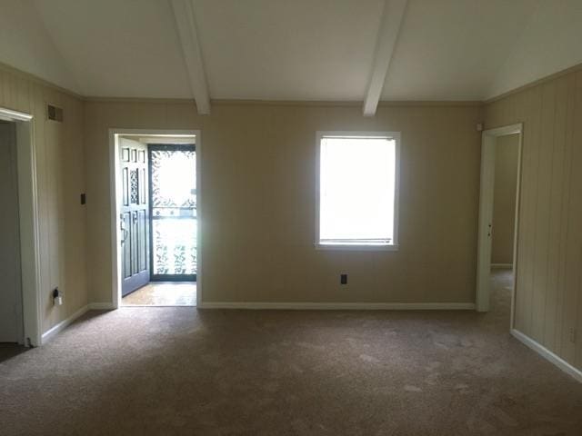 spare room with visible vents, light carpet, lofted ceiling with beams, and baseboards