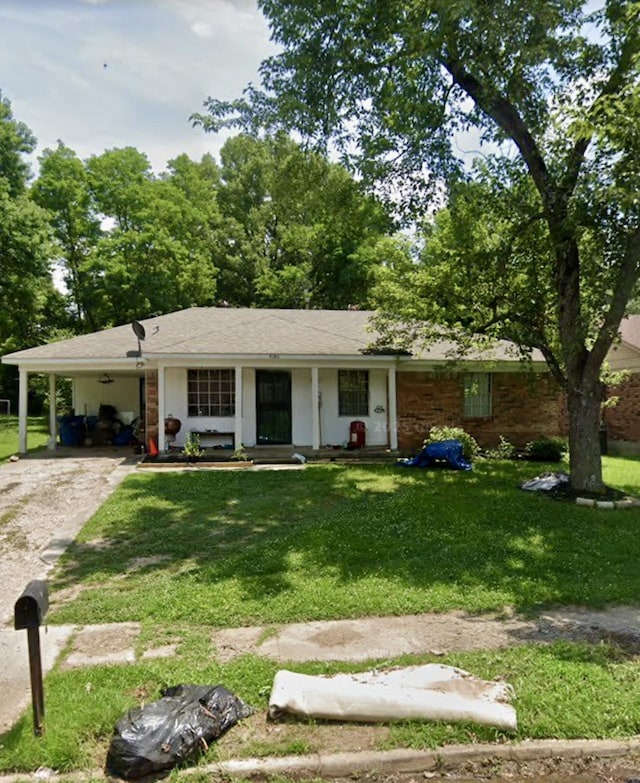 ranch-style home with driveway, an attached carport, and a front yard