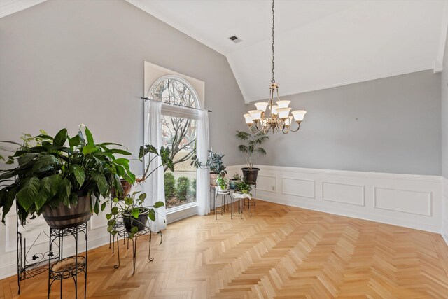 living area featuring a notable chandelier, a decorative wall, ornamental molding, wainscoting, and vaulted ceiling