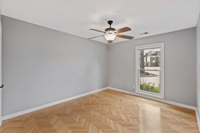 unfurnished room featuring a ceiling fan, visible vents, and baseboards